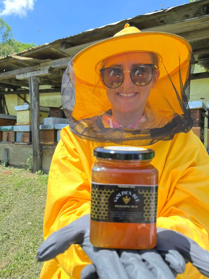Pčelarka Golden Bee BiH drži teglu meda ispred porodičnog pčelinjaka